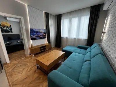 a living room with a blue couch and a table at Monaco 100 Sq M 3BDR Apt on Oborishte street with WiFi in Sofia