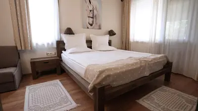 a bedroom with a large bed with white sheets and pillows at Комплекс Белите скали in Gaytaninovo