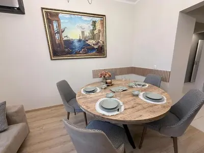 a dining room table with chairs and a painting on the wall at New top center cozy 3 bedroom apartment in Sofia