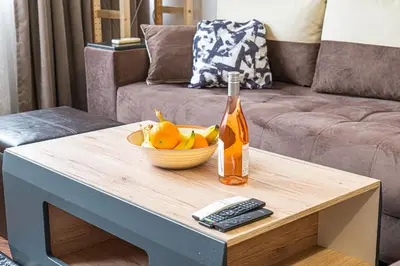 a table with a bowl of fruit and a bottle on it at Modern 1-Bedroom Apartment in Absolute City Center in Sofia