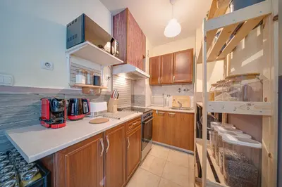 a kitchen with wooden cabinets and a counter top at Modern 1-Bedroom Apartment in Absolute City Center in Sofia