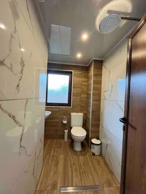 a small bathroom with a toilet and a window at Стаи за гости Царвулджиеви in Koprivshtitsa