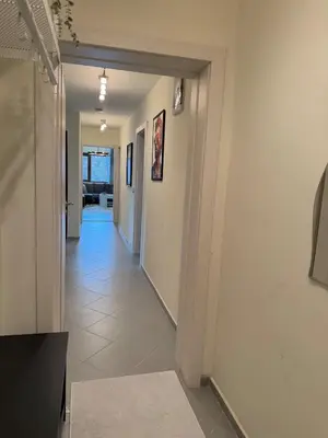 a hallway with white walls and a white tile floor at New cozy 3 bedroom apartment 90m2 in Sofia