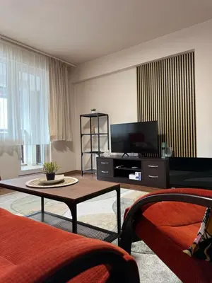 a living room with a couch and a tv at Gino's place Home2Host in Bansko