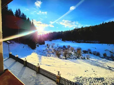 a winter view of a snowy field with the sun setting at Daisy Forest in Borino