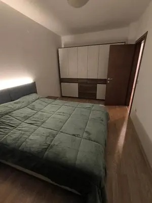 a bedroom with a large bed and a cabinet at Sasha Yo in Razlog