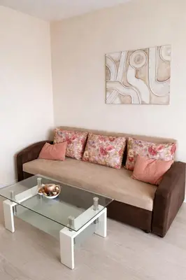 a living room with a brown couch and a glass table at Old Town Prime Apartment & Parking in Plovdiv