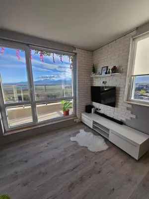 a living room with large windows and a television at Desitas home in Plovdiv