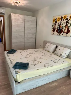 a large bed in a bedroom with a painting on the wall at 5 minutes sity center plus parking in Plovdiv