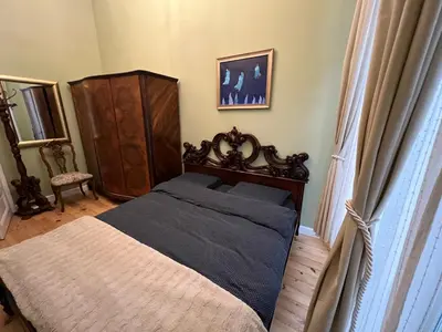a bedroom with a large bed and a dresser at Belview Apartment with Panoramic Old Town View in Plovdiv