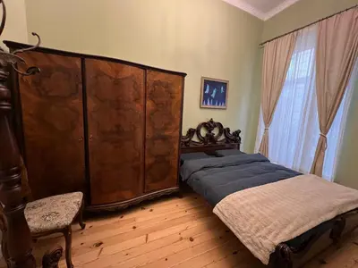 a bedroom with a bed and a large wooden cabinet at Belview Apartment with Panoramic Old Town View in Plovdiv