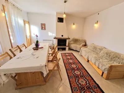 a living room with a table and a couch at The House in Stoykite