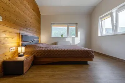 a bedroom with a large bed and two windows at Вила Звездопад in Manastir
