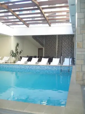 a large swimming pool with white pillows and chairs at Predela Apartments with Spa in Bansko