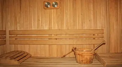 a wooden sauna with a bucket and a bench at Predela Apartments with Spa in Bansko