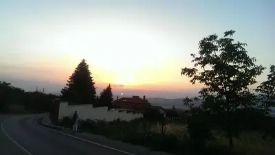 a road with the sun setting in the distance at Mini Complex Rilski Terasi in Sapareva Banya