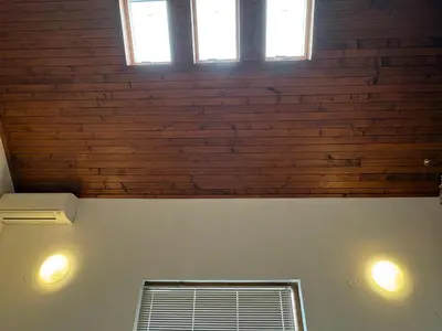 a room with two windows and a brick wall at Mountain Family Guest House Rayovo in Rayovo