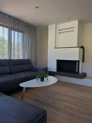 a living room with a couch and a table at Резиденция БАЛМОРА in Kalofer