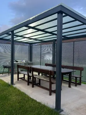 a pavilion with benches and tables with a view of the water at Резиденция БАЛМОРА in Kalofer