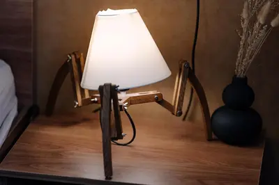 a wooden chair with a white lamp on a table at NDK - UrbanLux Medius 2BDR FREE Parking in Sofia