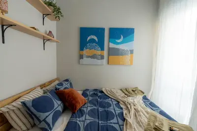 a bedroom with a bed with a blue comforter at NDK - UrbanLux Medius 2BDR FREE Parking in Sofia