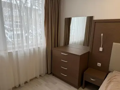a bedroom with a dresser and a bed and a window at Velingrad Prime 2-Bedroom Apartment in Velingrad