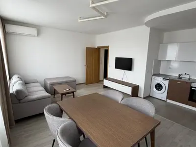 a living room with a table and chairs and a kitchen at Velingrad Prime 2-Bedroom Apartment in Velingrad