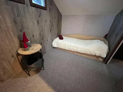 a small bedroom with a bed and a small table at Delight House in Samokov