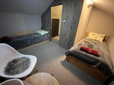 a bedroom with two beds and a chair and a mirror at Delight House in Samokov