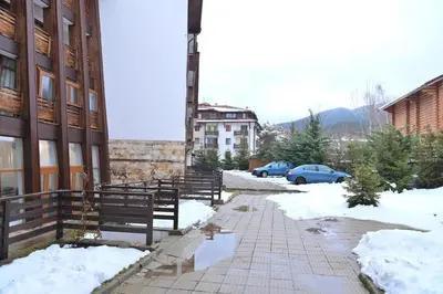 a snow covered sidewalk next to a building with benches at The Mountain Hug Studio 1 by SI Stay in Bansko