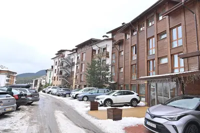 a snow covered street with cars parked in front of buildings at The Mountain Hug Studio 1 by SI Stay in Bansko