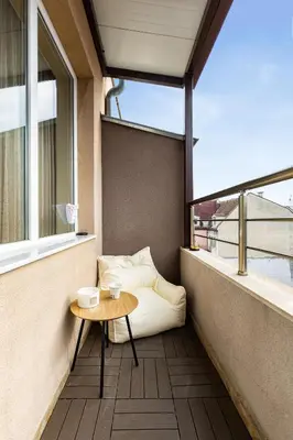 a balcony with a coffee table and a couch at Sunny Modern 1BR Retreat with Cozy Balcony in Plovdiv