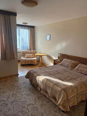 a hotel room with a bed and a chair at Kalaydzhiev rooms in Bansko