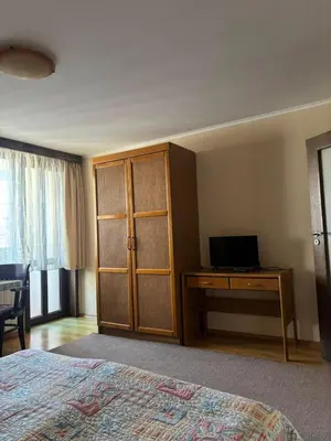 a bedroom with a bed and a desk with a computer at Kalaydzhiev rooms in Bansko
