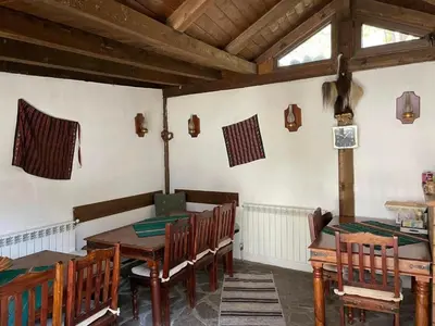 a dining room with a wooden table and chairs at Kalaydzhiev rooms in Bansko