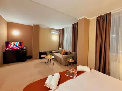 a hotel room with a bed and a couch at Hotel NIRÁ in Sofia