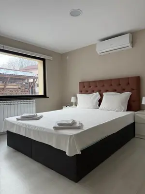 a bedroom with a large bed with white sheets at Къща за гости Зорница in Ribarica