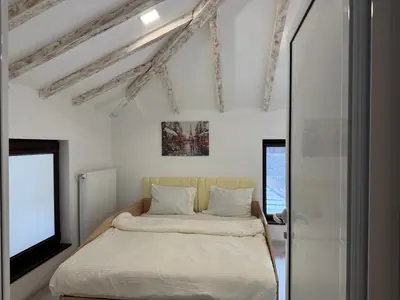 a white bedroom with a bed and a tv at Къща за гости Зорница in Ribarica