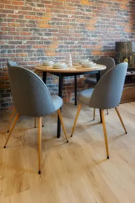a table and chairs in a room with a brick wall at SkyCloud Bansko Cozy Modern 1 Min to Gondola in Bansko