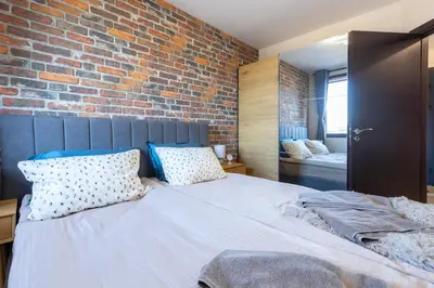 a bedroom with a brick wall and a bed with pillows at SkyCloud Bansko Cozy Modern 1 Min to Gondola in Bansko