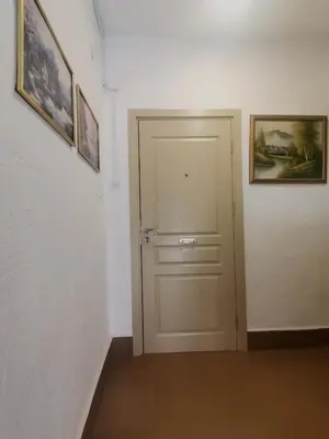 a white door in a room with pictures on the wall at Апартамент Релакс in Velingrad