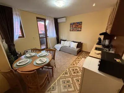 a kitchen and living room with a table and a couch at Пампорово Mountain Lodge апартамент 46 in Pamporovo
