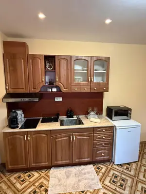 a kitchen with wooden cabinets and a sink and a refrigerator at Пампорово Mountain Lodge апартамент 46 in Pamporovo