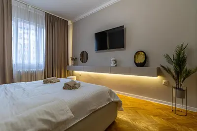 a bedroom with a bed and a tv on the wall at Grand Stamboliyski Residence in Sofia