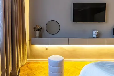 a bedroom with a tv on the wall and a mirror at Grand Stamboliyski Residence in Sofia