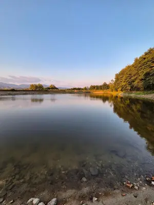 a large body of water with trees in the background at Бунгала ЛАГО