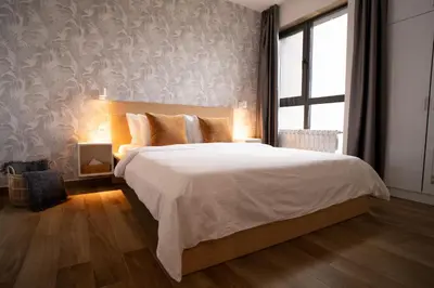 a bedroom with a large bed and a window at Blue Sky Penthouse with Parking Spot and Panorama Views in Sofia