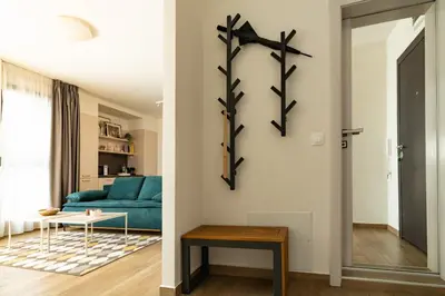 a living room with a blue couch at Sunny Penthouse with Mountain Views and 180 degrees Terrace in Sofia