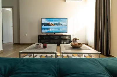a living room with a couch and a flat screen tv at Sunny Penthouse with Mountain Views and 180 degrees Terrace in Sofia
