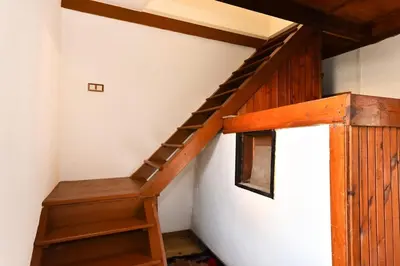 a wooden stairwell in a room with a wooden railing at Cozy house in the heart of Pirin mountain in Razlog